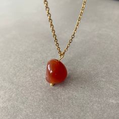 "NATURAL CARNELIAN CHAIN NECKLACE This necklace features a dainty, natural gemstone threaded on a 14k Gold Filled, Stainless Steel chain. Available in color options, this necklace is ideal for layering & makes the perfect gift! Please visit our store for other color options! Carnelian gives courage and promotes positive life choices. Carnelian is a crystal of action, overcoming procrastination or indecision. ☆ Each of the stones we use to create necklaces were formed by nature over years. Each one is unique and beautiful just like nature itself.  We do not process or change our stones in any way, we accept their \"unique and raw\" beauties. We don't polish away \"flaws\" in the stones but rather leave them in their natural state.  Just like people, each stone has special characteristics un Gem Stone Necklace, Raw Carnelian, Overcoming Procrastination, Orange Gem, Necklace Orange, Carnelian Pendant, Gem Necklace, Personalized Pendant, Life Choices