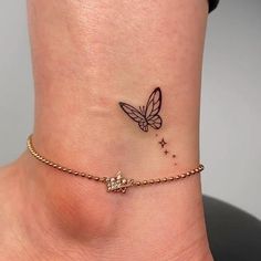 a small tattoo on the ankle of a woman's foot with a butterfly and stars