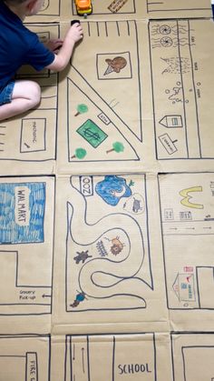 a young boy sitting on top of a cardboard map