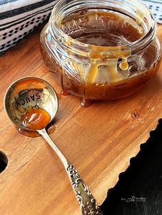 a spoon with honey on it sitting next to a jar