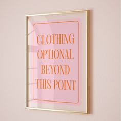 a pink and gold framed poster with the words clothing optional beyond this point on it