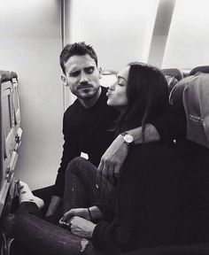 a man sitting next to a woman on an airplane