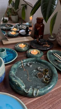 a table topped with plates and bowls filled with candles