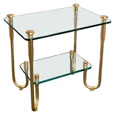 a glass and brass end table with two shelves