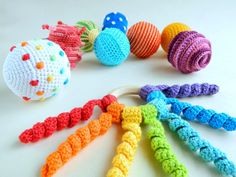 several crocheted toys are arranged in a circle on a white surface, including balls and chains