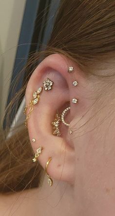 a close up of a person's ear with some piercings on top of it