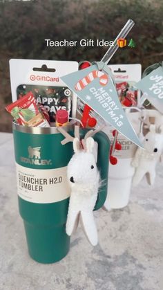 a cup filled with candy sitting on top of a table next to two small plastic animals