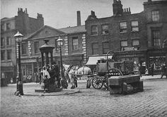 an old black and white photo of horse drawn carriages on a cobblestone street