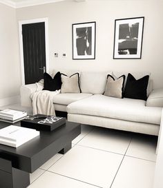 a black and white living room with couches, coffee table and pictures on the wall