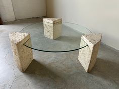 a glass table with two stone blocks sitting on it's sides in an empty room