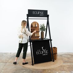 a woman standing in front of a display case with plants on it's sides