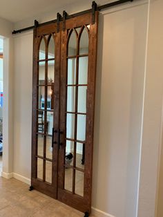 the interior of a house with double doors and mirrors on the wall, along with tile flooring