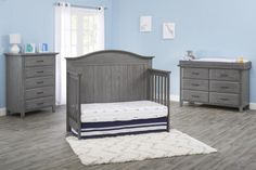 a baby's room with gray furniture and blue walls