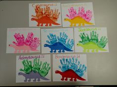 four handprints of different dinosaurs are displayed on a table