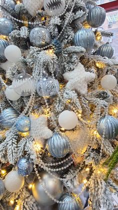 a christmas tree with silver and white ornaments