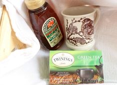 the contents of a tea bag, cup, and saucer on a white blanket