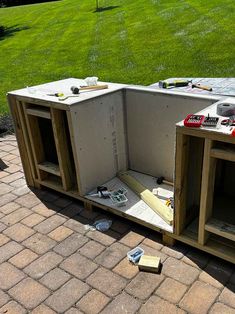 an outdoor kitchen is being built on the ground with tools and construction materials scattered around it