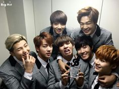 a group of young men standing next to each other in front of a bathroom mirror