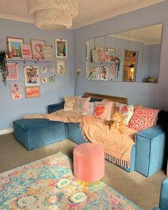 a living room with blue couches and pictures on the wall above them, along with rugs