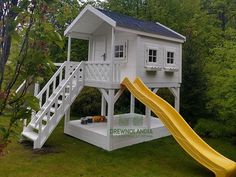 a white house with a yellow slide in the yard