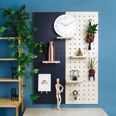 there is a clock on the wall next to some plants and other things in front of it