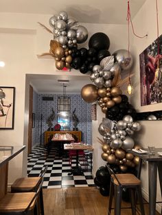 the balloons are hanging from the ceiling in the kitchen and dining room, along with other decorations