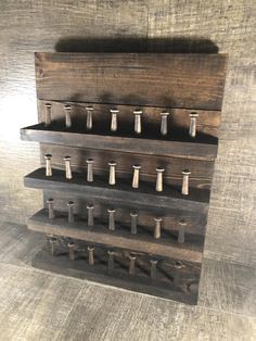 a wooden display case with metal nails on it's sides and two rows of holes in the middle