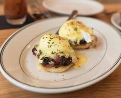 two eggs benedicts are sitting on a plate