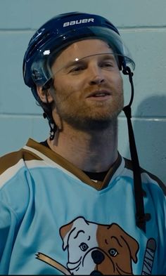 a man wearing a hockey uniform with a dog on it's shirt and helmet