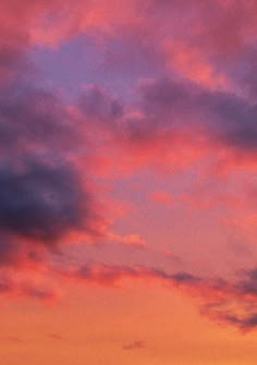 an airplane is flying in the sky at sunset or dawn with pink and purple clouds