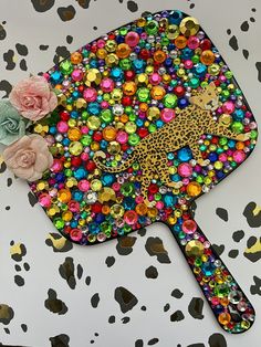 a colorful object with flowers on it sitting on top of a leopard print table cloth