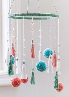 a mobile with tassels and pom - poms hanging from the ceiling