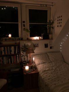 a bedroom with a bed, window and bookshelf in the corner at night