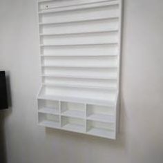 a white shelf mounted to the side of a wall