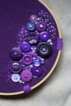 a close up of a purple piece of art with buttons on the front and back