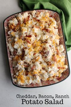 potato salad with bacon, ranch and cheese in a square dish on a white table