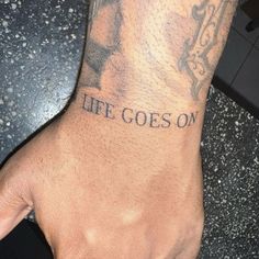 a man with a tattoo on his arm that says life goes on