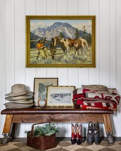 there is a painting on the wall next to a table with hats and other items