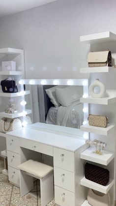 a white vanity with lights on it next to a bed