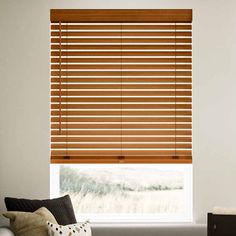 a living room with a couch and window covered in wooden blinds that have horizontal shades