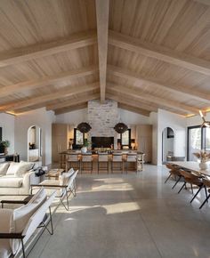 a large open living room with high ceilings and wooden beams on the ceiling is shown