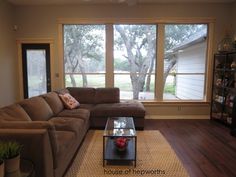 a living room filled with furniture and large windows