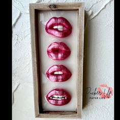 four pink lips are in a box on the wall