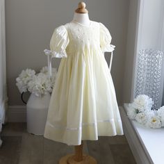 This Gorgeous Strasburg Pastel Pale Yellow Hand-Smocked Girls Float Style Dress Is In Perfect Condition. The Bodice Is Completely Hand Smocked In Yellow And White And Has White Embroidered Flower Details With Yellow Centers. The Gathered Puff Sleeves Are Trimmed In White Satin Ribbon Which Ties In A Bow And Are Finished Off With A Delicate Crocheted Cotton Lace. The Skirt Has A Lovely White Satin Ribbon Band With An Attached Delicate Crocheted Cotton Lace Trim. The Dress Is Fully Lined And Has A Button Back Closure With A Sash That Ties Into A Bow. Great For Weddings, Church, Portraits, Vacation Or Any Special Occasion. Matching Sister/Cousin Dresses Available In Sizes 6/9 Months, 24 Months Heirloom Dress Patterns, Matching Sisters, Hand Smock, Pale Yellow, White Satin, Cotton Lace, Embroidered Flowers, Satin Ribbon, Kids' Dresses