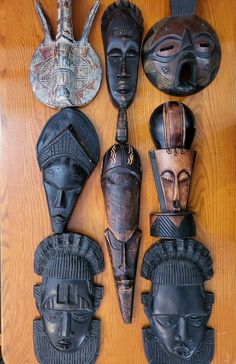 african masks are arranged on a wooden surface