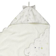 a white blanket with sheeps and clouds on the front, hanging from a hook