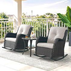 two wicker rocking chairs on a patio with a coffee table and plant in the background