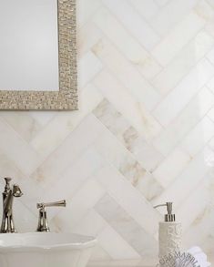 a white sink sitting next to a mirror in a bathroom under a faucet