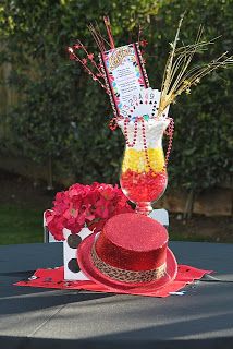 a red hat sitting on top of a table covered in flowers and candy canes