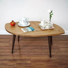 a wooden table with two cups and saucers on it